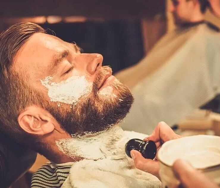 Hombre con espuma de afeitar en el rostro - Homme Luxury Barbers