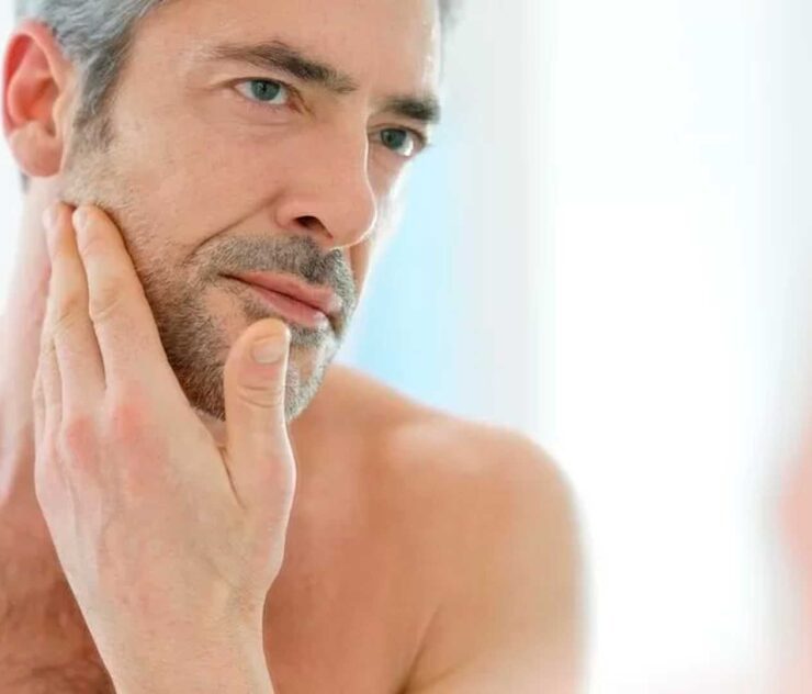 Hombre observando su rostro en el espejo - Homme Luxury Barbers