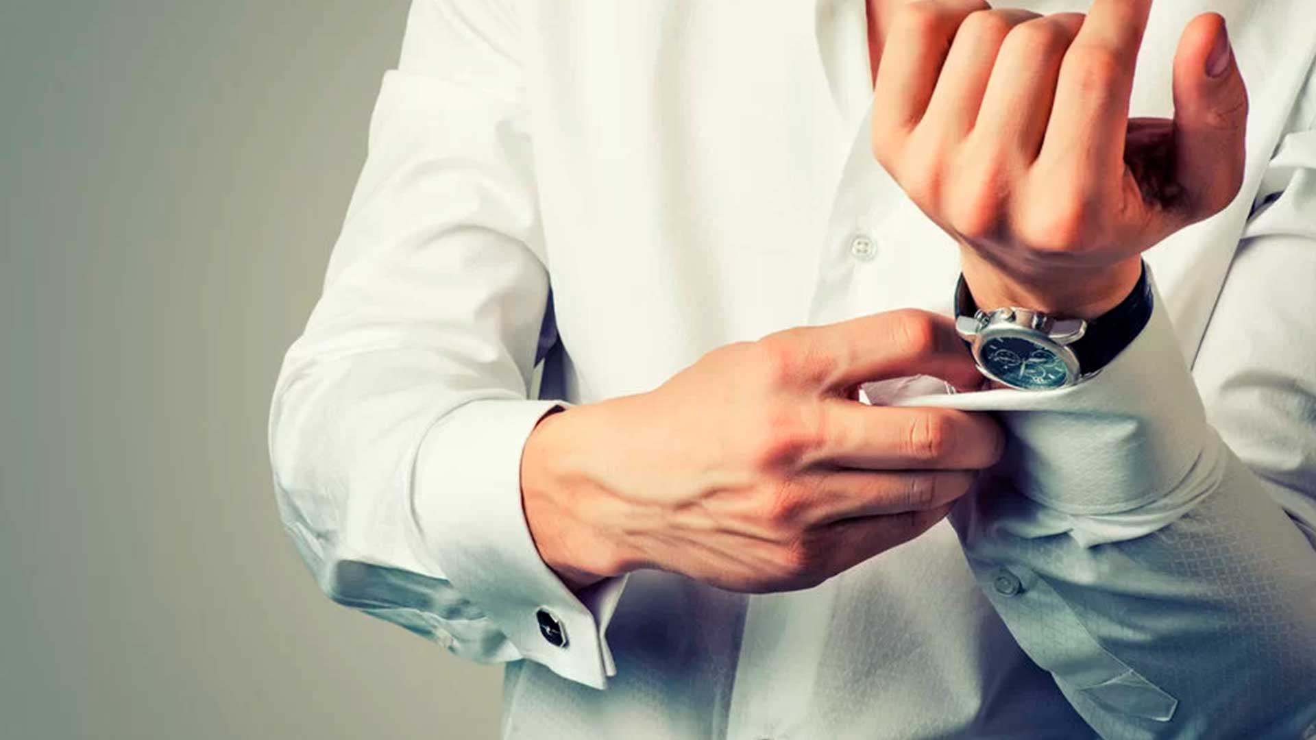 Hombre abrochandose el puño de la camisa - Homme Luxury Barbers