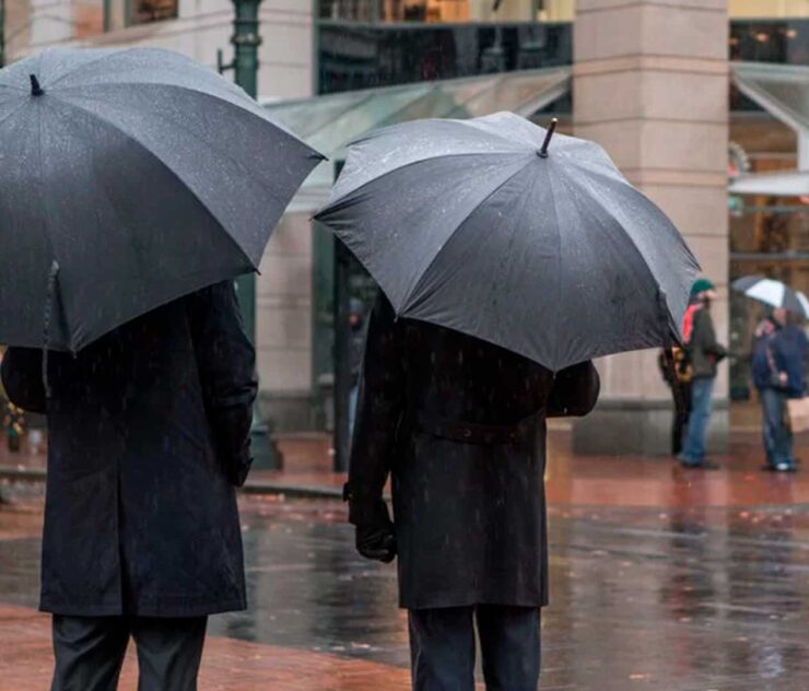 Dos personas utilizando paraguas bajo la lluvia - Homme Luxury Barbers
