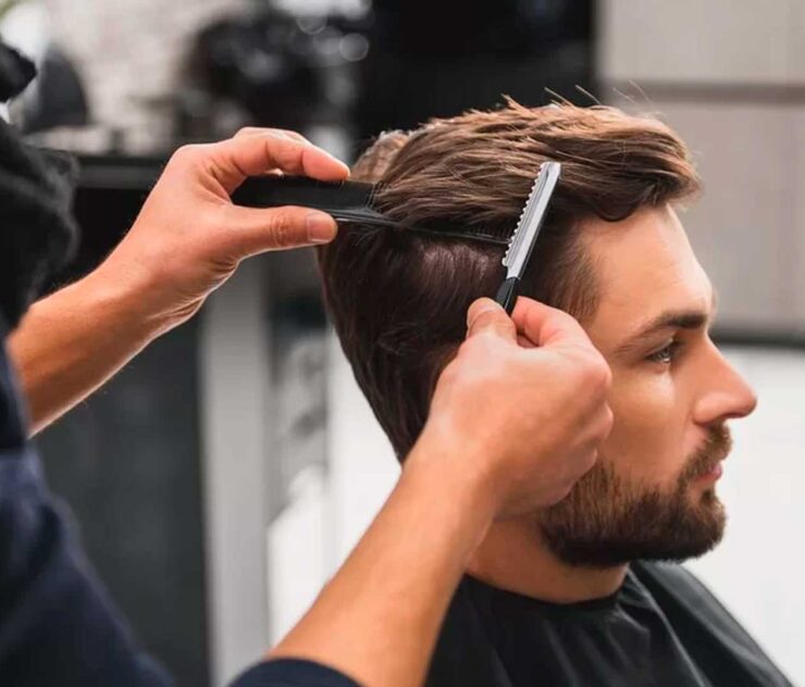 Hombre recortándose el cabello en la barbaería - Homme Luxury Barbers