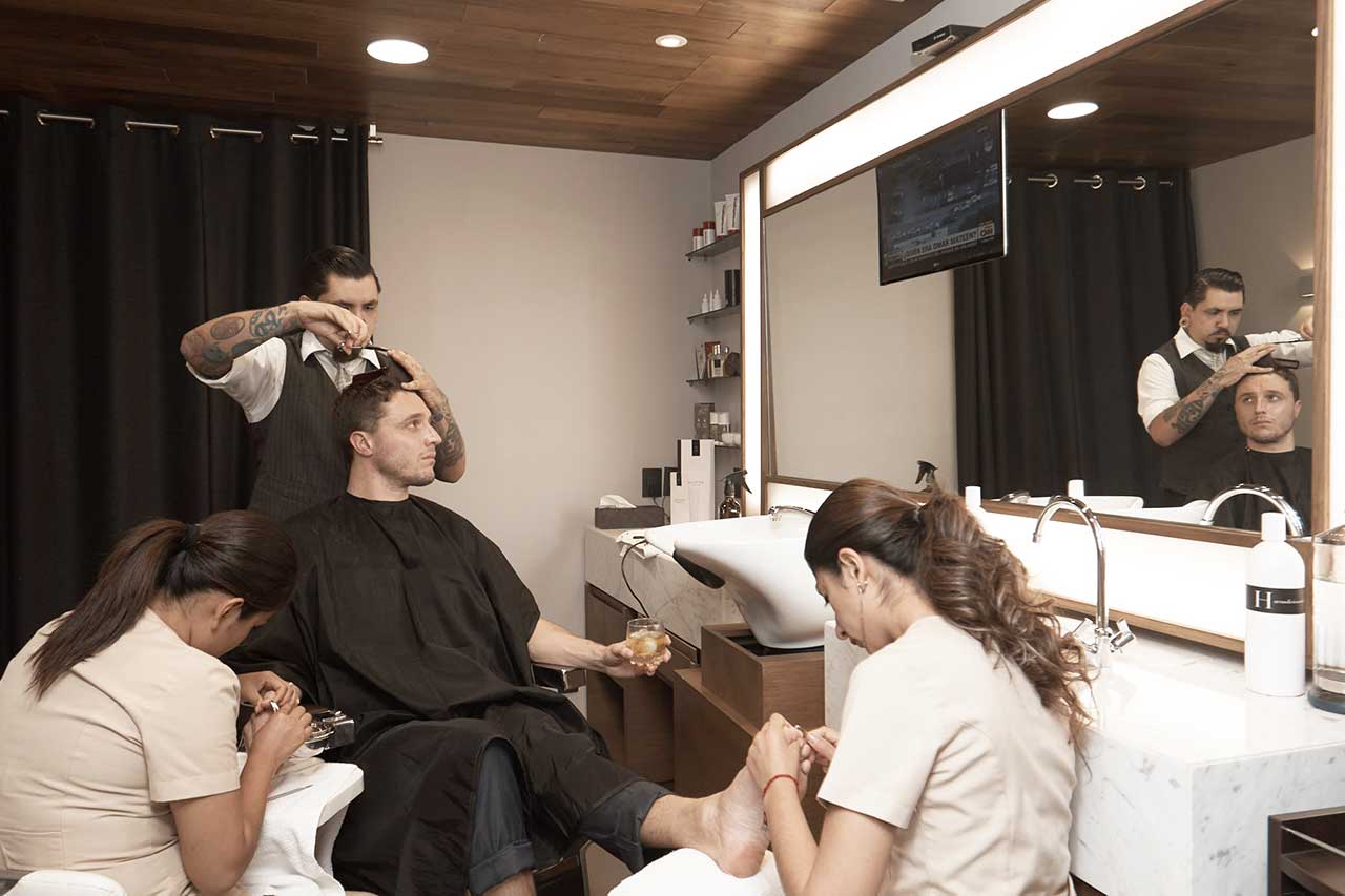 Hombre disfrutando de los servicios de barbería y manicuría - Homme Luxury Barbers