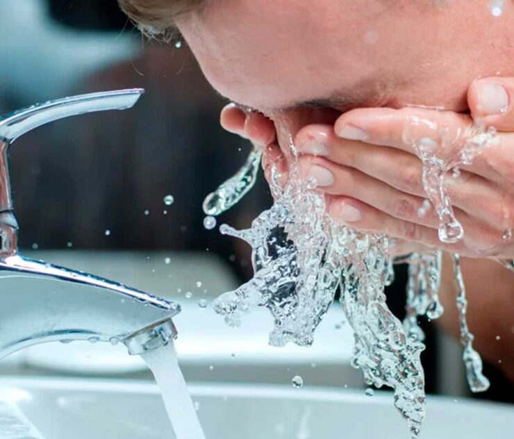 Hombre enjugándose el rostro con agua - Homme Luxury Barbers