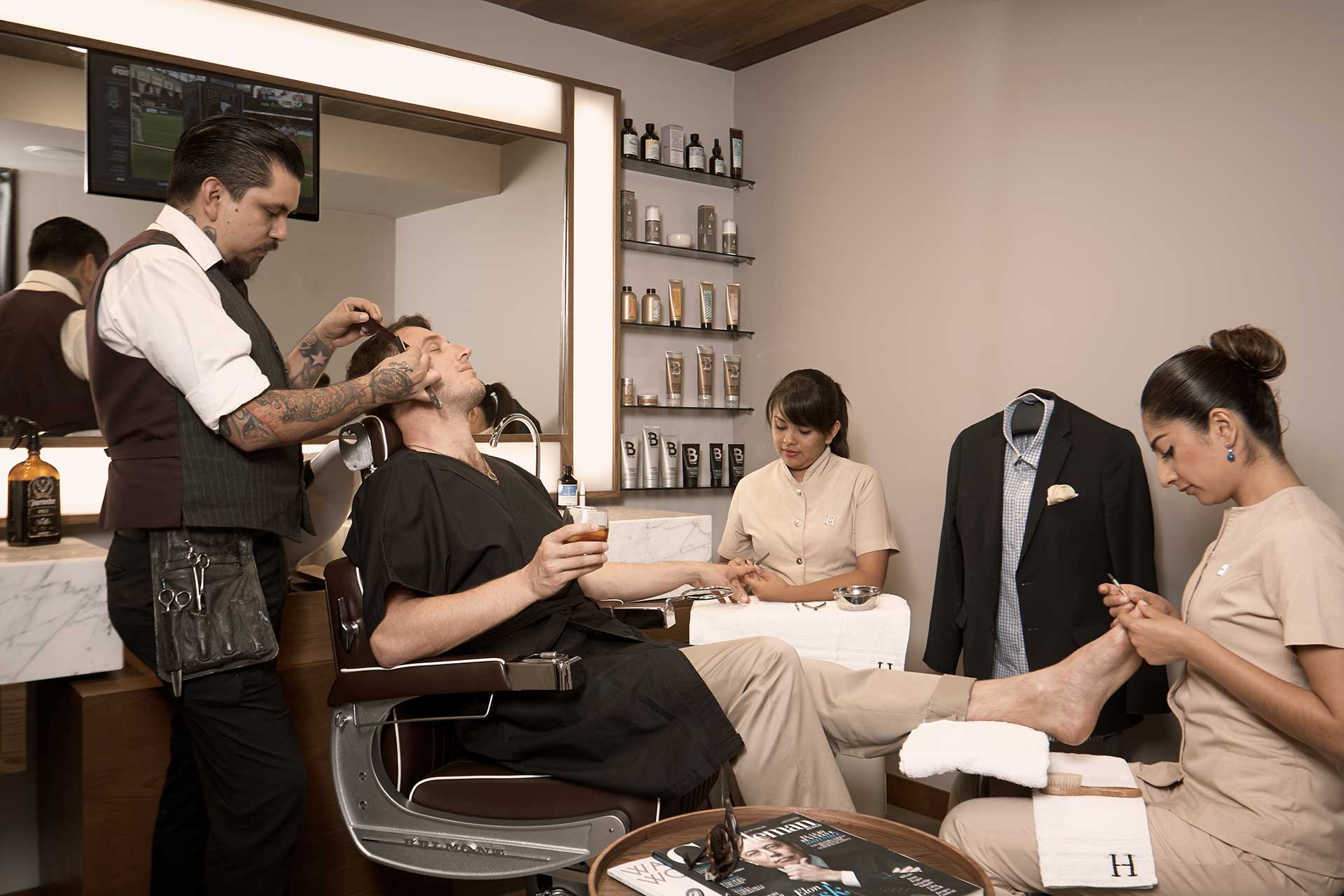 Cliente masculino disfrutando de servicios de barbería y manicuría - Homme Luxury Barbers