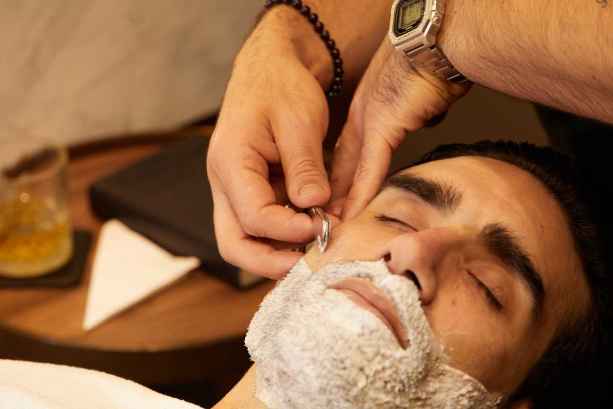 peluqueria-y-barberia-homme-luxury-barbers-18 Hombre en proceso de afeitado de barba